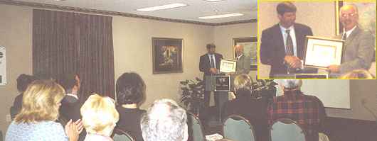 Dennis accepting an award from Claude Gagne of 